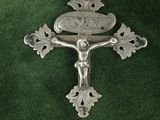 cross on a green cloth with a silver cross on top of it
