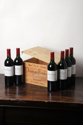 plusieurs bouteilles de vin sont alignées sur une table en bois