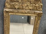 mirror with gold frame and ornate decoration on top of it