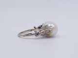 a white pearl and diamond ring on a white background