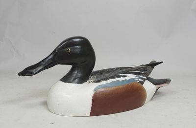 an image of a wooden duck sitting on top of a white surface