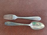 two spoons and a fork sitting on a table