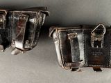 two leather holsters that are on a table