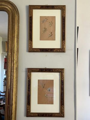 trois tableaux encadrés accrochés au mur au-dessus d'un miroir