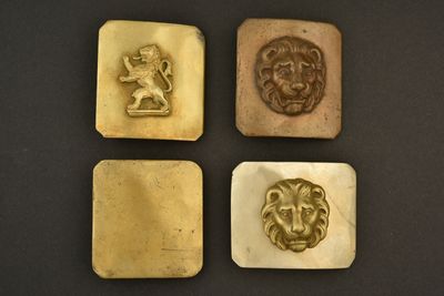 quatre têtes de lion plaquées or et une tête de lion sur fond noir
