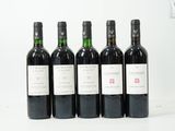 six bouteilles de vin sont alignées sur une surface blanche