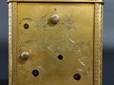 pair of antique brass clock stands on a black surface