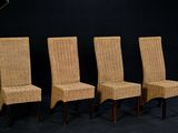 trois chaises en osier sont alignées devant un fond noir