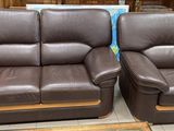 pair of brown leather recliners on display in a store