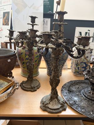 une table sur laquelle sont disposés de nombreux vases en argent