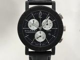 La montre est noire, avec un cadran blanc et un bracelet en cuir noir.