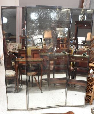 un miroir au milieu d'une pièce, avec une table et des chaises en arrière-plan