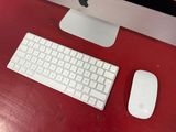 a keyboard, mouse, and monitor on a red desk