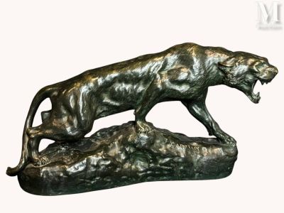 bronze statue of a lion on a rock with its mouth open