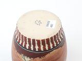 a brown and white vase sitting on a white surface