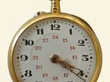 gros plan d'une montre de poche en or sur fond blanc