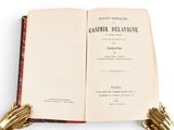 an open book with a gold glove on top of it