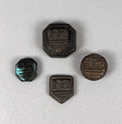 three small metal objects are sitting on a white surface