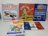 plusieurs livres posés sur une table blanche, avec une petite voiture et un petit camion