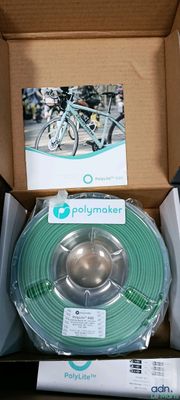 une boîte contenant un rouleau de filament vert