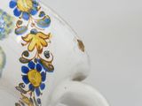 a white cup with blue and yellow flowers on it