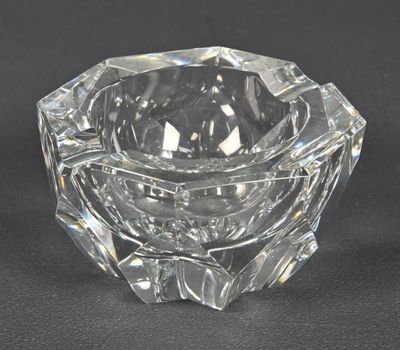 a clear glass candle holder on a black surface