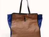 an image of a brown and blue handbag sitting on top of a white surface