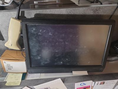 un téléviseur posé sur un bureau recouvert de papiers