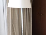 a lamp that is sitting on the floor in front of a window