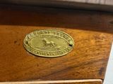 a brass plaque on the top of a wooden cabinet
