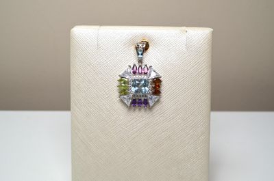 Un pendentif en argent, serti au centre d'une topaze facetté…