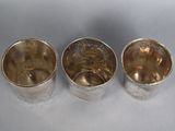 three silver cups sitting next to each other on top of a table