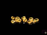 a close up of a pair of yellow earrings on a black surface