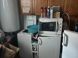 une petite cuisine équipée d'un réfrigérateur, d'un micro-ondes et d'un réfrigérateur-congélateur