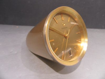 une horloge en or posée sur une table blanche