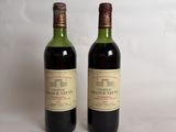 two bottles of wine sitting next to each other on a white surface