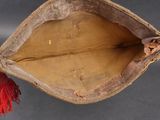 a brown bag with a red tassel hanging from it