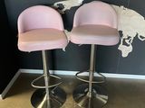 two pink bar stools in front of a map of the world
