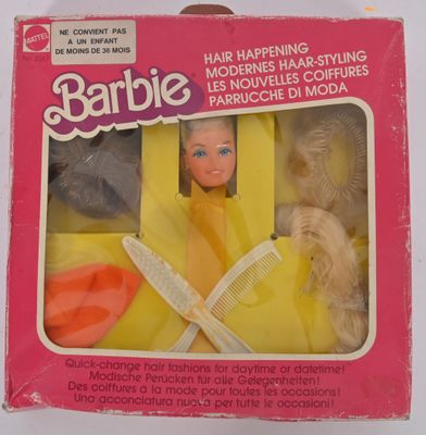 poupée dans une boîte avec des accessoires de coiffure, des brosses à cheveux, des produits de coiffure, des ciseaux et des ombrelles
