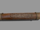 an old wooden stick with a carved design on it