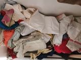 a pile of clothes sitting on top of a refrigerator
