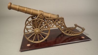 maquette en bois d'un canon posé sur un socle, sur fond blanc