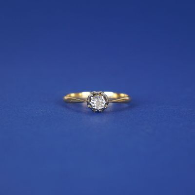 une bague de fiançailles ornée d'un diamant sur fond bleu