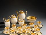 a group of silver and gold tea and coffee cups and saucers