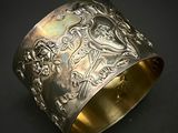 gros plan d'un bracelet en argent sur une surface noire