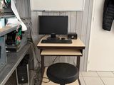 a desk with a computer and a chair in a room