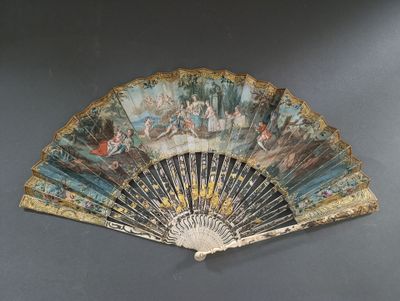 un éventail avec un tableau posé sur une table