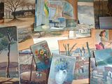 de nombreux tableaux exposés dans une pièce où un tableau est accroché au mur