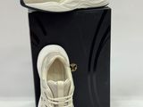 a pair of white sneakers sitting on top of a black box
