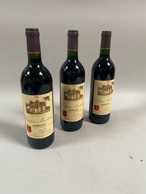trois bouteilles de vin posées sur une table l'une à côté de l'autre